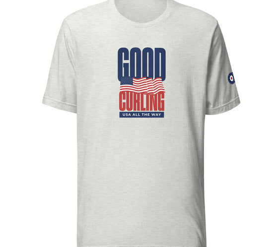 Front view of the “Good Curling USA All The Way” T-shirt featuring a bold navy and red graphic with a waving American flag and “Good Curling” text, printed on a lightweight ash gray tee.