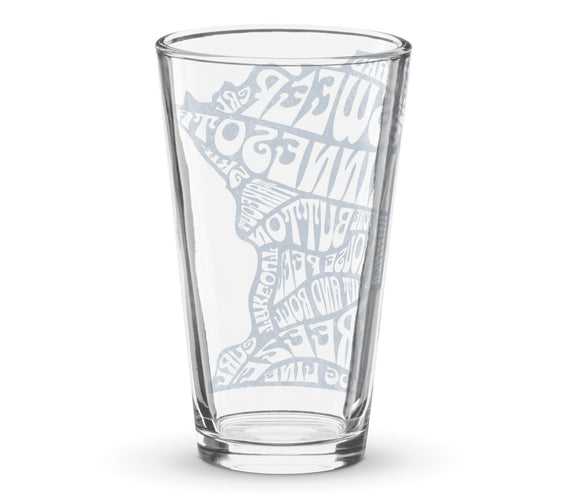 Clear shaker pint glass featuring a frosted white Minnesota state outline filled with curling terms like sweep, guard, button, house, freeze, and hog line. Curling-themed pint glass by CRL.
